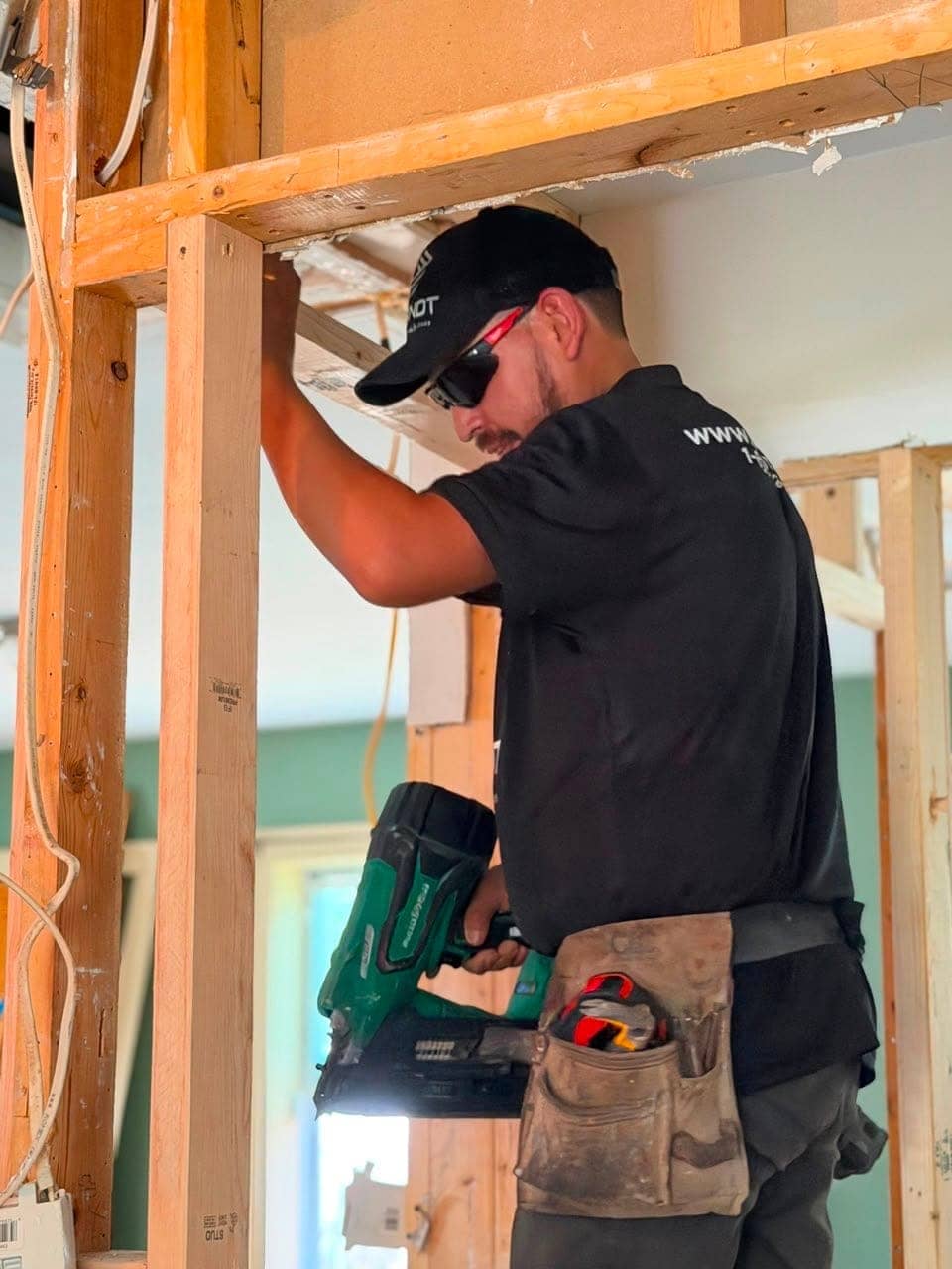 Worker using a framing nailer